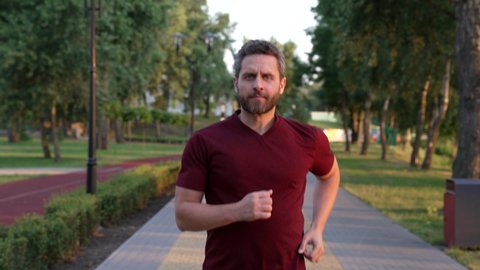 athletic man running in park outdoor facing sunset, aerobic load