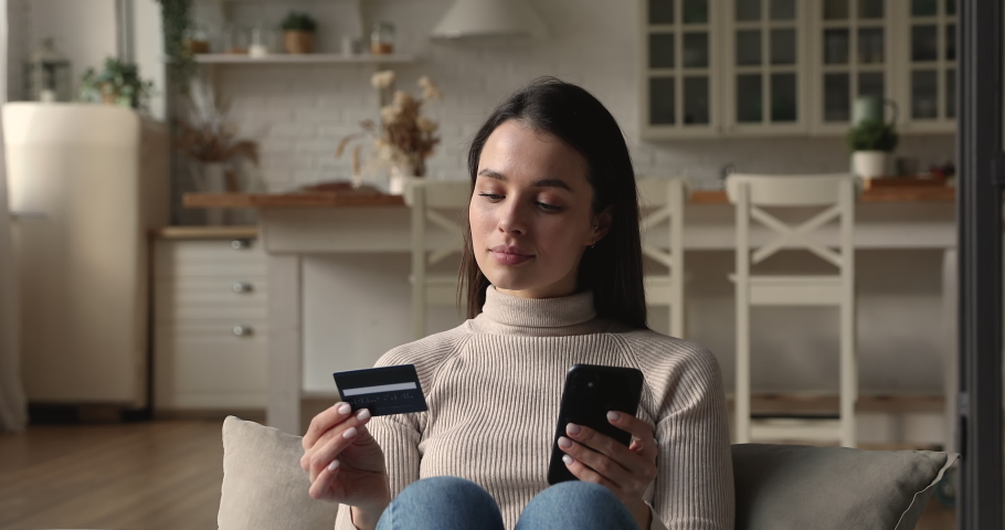 Happy focused young woman entering payment information form plastic card in cellphone application, shopping in internet store, purchasing goods or paying for services online, ecommerce concept. Royalty-Free Stock Footage #1077576596