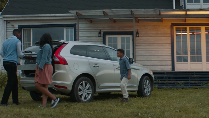 TRACKING Happy African American family of three arriving by car to their new house. Shot with 2x anamorphic lens