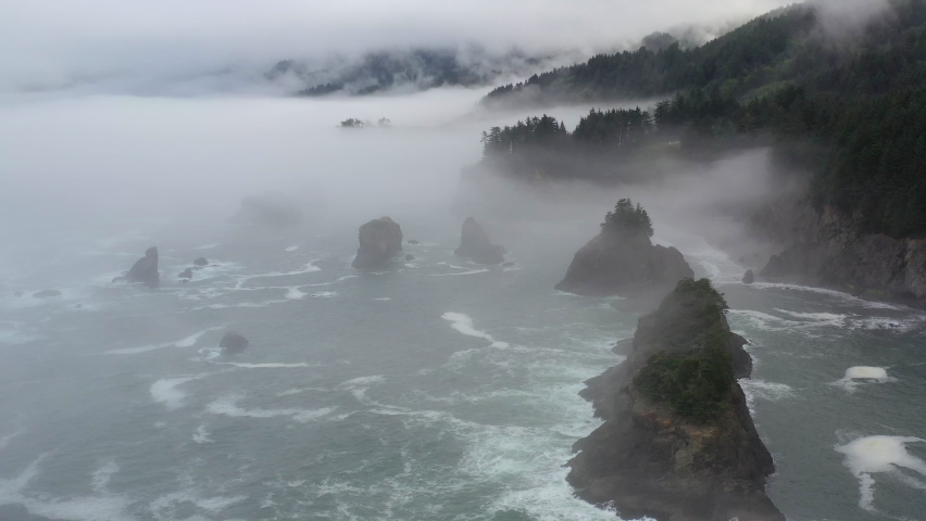 Fog drifts across the scenic coast of southern Oregon. This beautiful yet rugged and rocky part of the Pacific Northwest is found along the Samuel H. Boardman State Scenic Corridor. Royalty-Free Stock Footage #1077581861