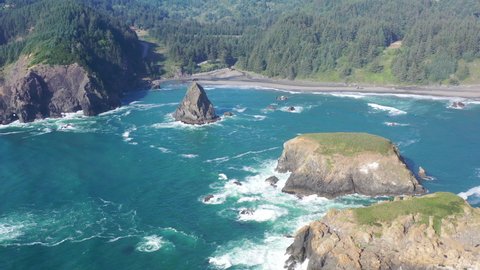 The Pacific Ocean washes against a sea stack and the scenic coast of southern Oregon. This rugged and rocky part of the Pacific Northwest is found along the Samuel H. Boardman State Scenic Corridor.