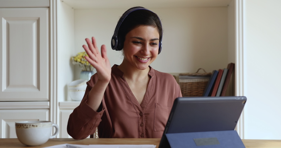 Happy young Indian woman in headphones start videoconference on digital tablet by business or study sit in homeoffice room. Video call event, apps, on-line tutor start virtual meeting class concept | Shutterstock HD Video #1077583892