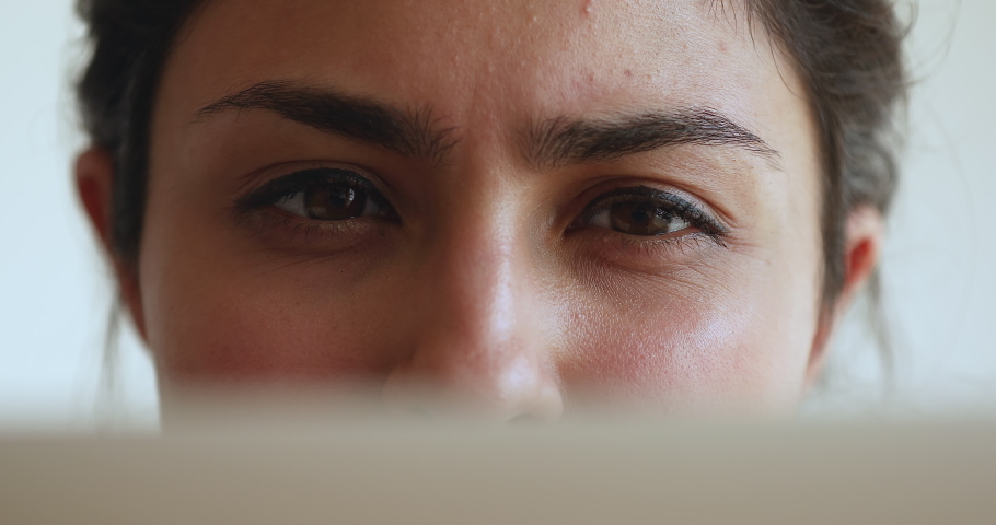 Close up cropped view Indian woman face part, eyes look at laptop screen. Computer work, drops for dry eyes prevent, vision check-up, laser correction surgery, eyesight care clinic services concept Royalty-Free Stock Footage #1077583949