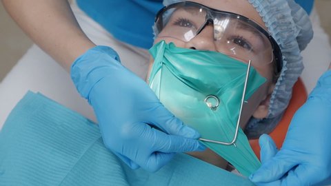 Dental treatment cofferdam in stomatology. Dentist using dental dam for tooth isolation