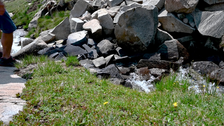 Hiker walking across Big Dutch Creek near Lake of the Clouds in Rocky Mountain National Park, Colorado, USA