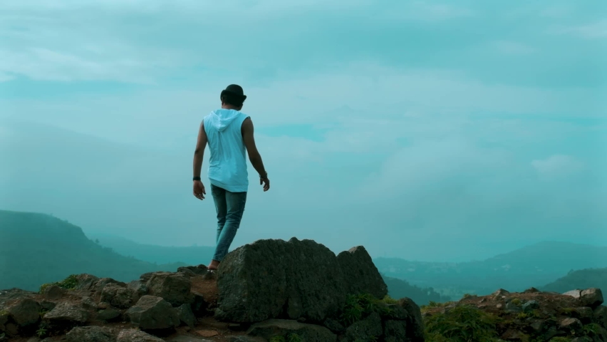 young guy  tracking mountaintop in beautiful weather cloudy sky