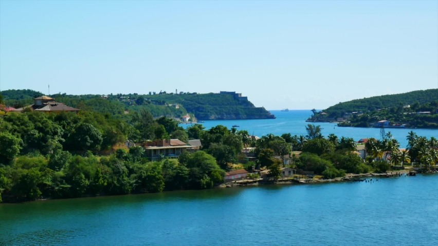 View of the entrance to the Santiago de Cuba bay. Some colorful buildings and coral beach 
