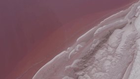 Flying over a pink salt lake. Clean Saline pattern texture. Large salt lake. Aerial drone top down view. High quality 4k footage