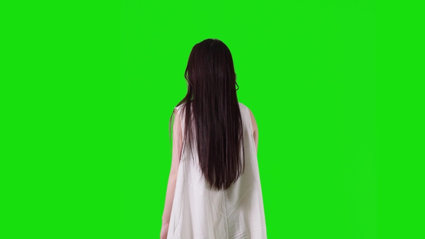 Young asian woman wearing white dress. Green background for chroma key composition.