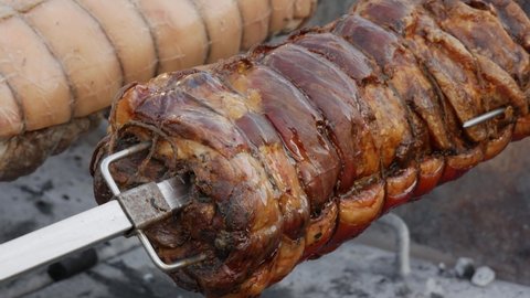 close up traditional italian recipe Roast porchetta, classic pork roll roasted on the grill on a spit