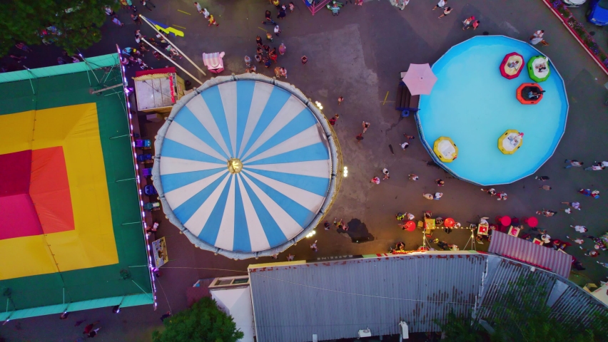amusement park aerial view, merry go round spinning, view from above, colorful urban luna park, fairgrounds in the city. High quality 4k footage Royalty-Free Stock Footage #1077616100