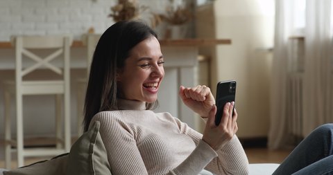 Overjoyed emotional happy millennial woman getting email or message with unbelievable news, feeling excited celebrating online lottery win, reading success notification, internet gambling concept.