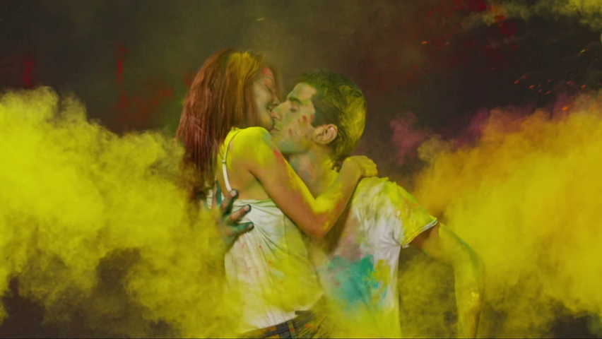 Young romantic couple kissing and hugging each other . Beautiful young people having fun and splashing colorful holi . Holi festival background . Slow Motion shot on RED EPIC Cinema Camera 300fps Royalty-Free Stock Footage #1077620819