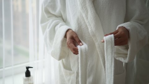 Beauty and spa procedures lady ties belt of bathrobe Spbd