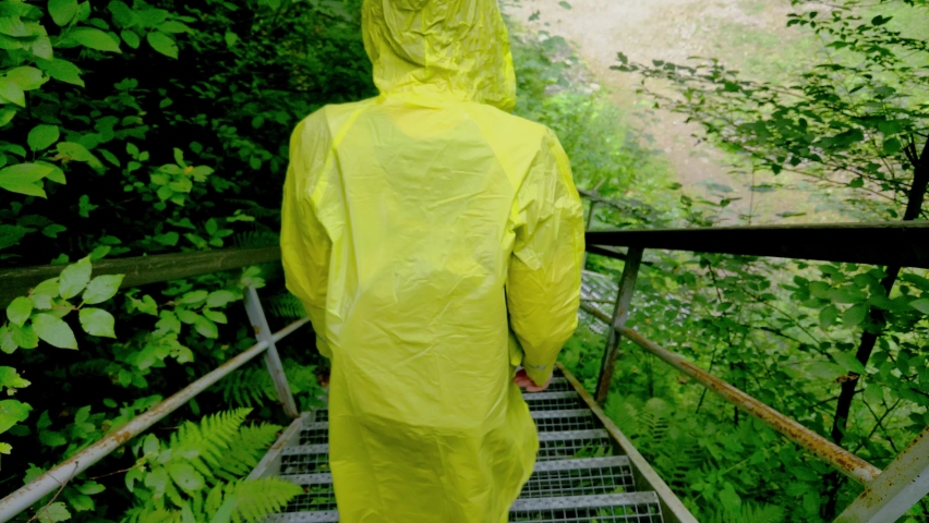 A man in a raincoat goes down the stairs