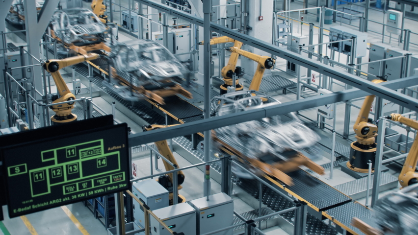 Car Factory 3D Concept: Automated Robot Arm Assembly Line Manufacturing High-Tech Green Energy Electric Vehicles. Construction, Building, Welding Industrial Production Conveyor. Fast Wide Shot Royalty-Free Stock Footage #1077627419