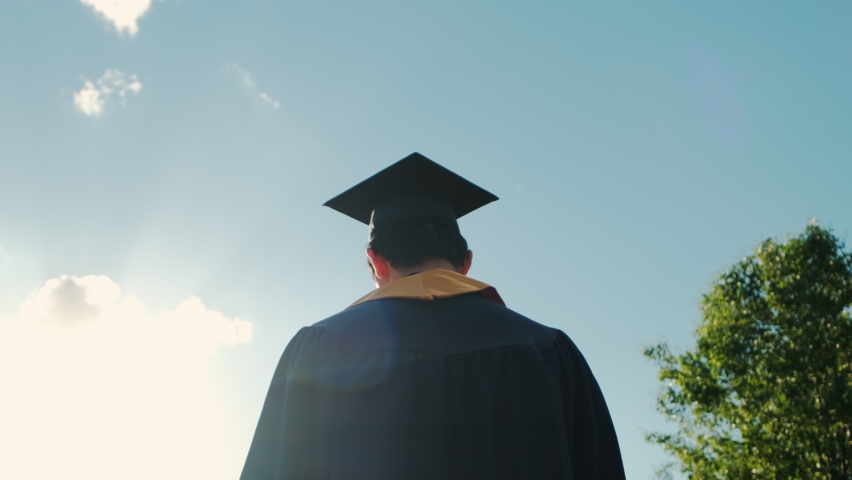 Rear view of the university graduates student at Silhouette sunset goes on the road. Close up shot Royalty-Free Stock Footage #1077632876