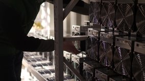 Loader brings in bitcoin ASIC miners to steel shipping container warehouse. Mover puts down mining equipment to stand racks for cryptocurrency mining farm. Workers carry loads to storage. - Powered by Shutterstock - Get 15% off with code: PIKWIZARD15