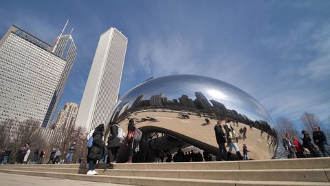 Chicago , Illinois , United States - 08 08 2021: People in Front of Cloud Gate aka Bean, Landmark in Millennium Park on Sunny Day. Slow Motion