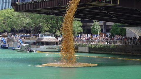 Chicago, IL - August 5th, 2021: A large dump truck backs up to the edge of Columbus Bridge and dumps 70,000 yellow rubber ducks into the river during the annual Special Olympics Ducky Derby event.