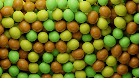 Multicoloured sugar sweets, candy beans or peanuts. Colorful candies filling all the area. Close up video. Holiday mood. Tasty assorted yellow, green, brown colored sweets. 3D Render 4K animation
