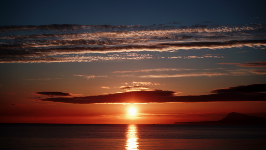 Time lapse of clouds moving over sea at early morning, sun rising. Nature landscape. View from Gandia beach, Valencia Spain.