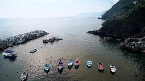 Riomaggiore, Italy - June 11. 2021: Picturesque town of Cinque Terre at Mediterranean Sea, panning from port to Riomaggiore Town