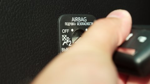 
Caucasian Male Activating Passenger Seat Car Airbag using Lock and Key Before Long Vacation Trip