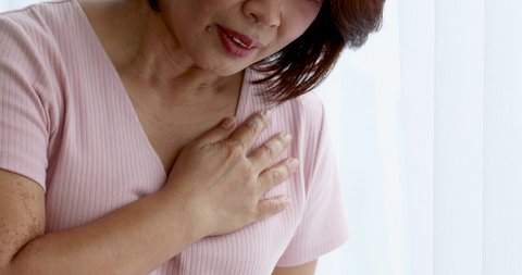 A senior woman suffered and pain from heart attack desease using hand holding chest on heart position. Concept of older person health care.