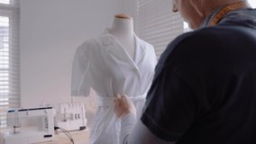 Caucasian female fashion student designing dress using mannequin
