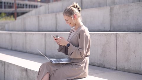 Young female using devices on street