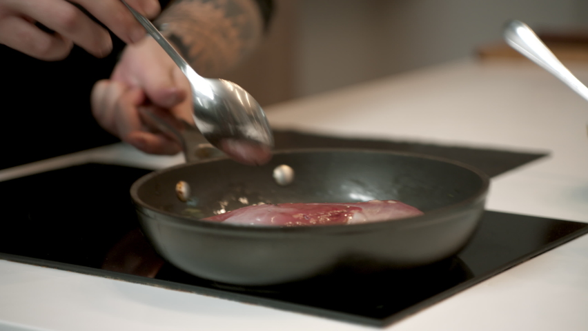 Cooking TV show celebrity host cooking a dish, talking into camera