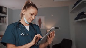 Caucasian female nurse typing on digital tablet