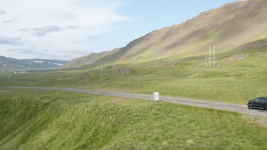 Black Pickup Car Towing Campervan On The Mountain Road In Westfjords, Iceland. aerial tracking Royalty-Free Stock Footage #1077685583