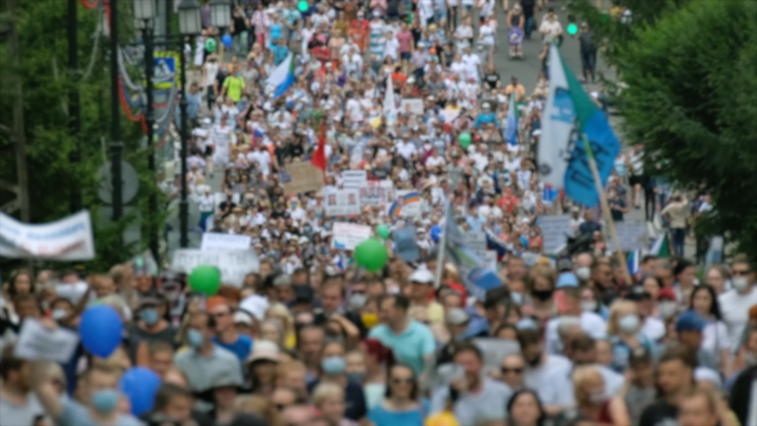 Protest people crowd on political riot in Russia marching on city streets, peaceful non-violent demonstration rally. Crowded protesters march with banners, placards, posters and signs on picket strike Royalty-Free Stock Footage #1077693512