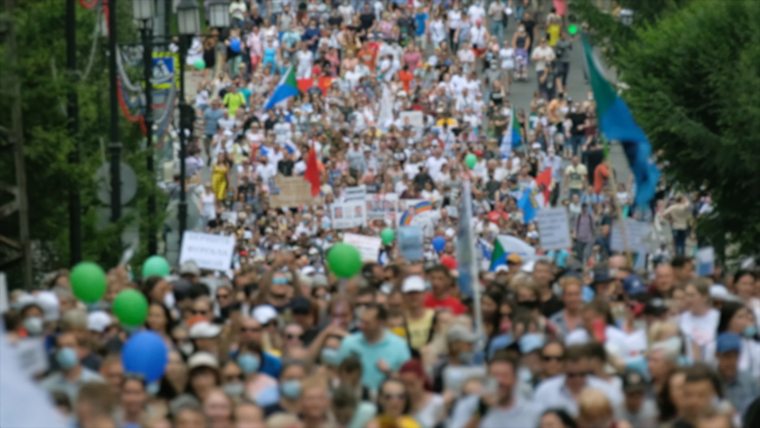Protest people crowd on political riot in Russia marching on city streets, peaceful non-violent demonstration rally. Crowded protesters march with banners, placards, posters and signs on picket strike Royalty-Free Stock Footage #1077693512