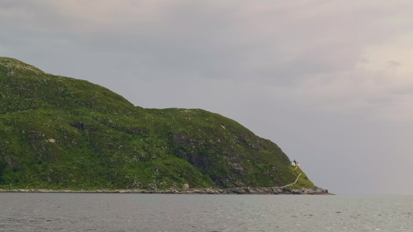 Distant View Of Hendanes Lighthouse At The Edge Of The Mountain In Maloy Region, Norway. wide shot