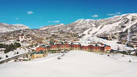 Aerial View Of Ski Lodge Near Ski Resort With Snowy Mountain In Background In Steamboat Springs, Colorado. - aerial drone shot