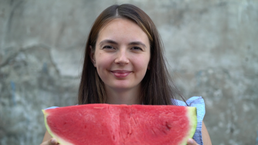 Portrait of a beautiful young woman eating watermelon.