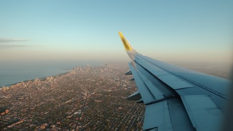 Flying into Chicago. flight with detail of plane with suburbs of Chicago below. Wide shot