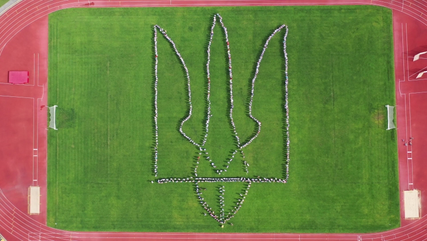 Coat of arms of Ukraine made up of people at the stadium. Aerial view, shooting from a drone. Ukraine