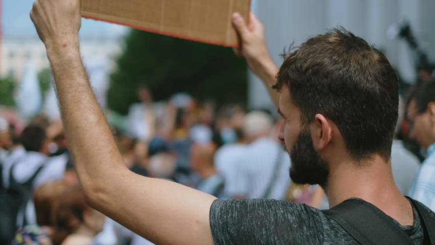 Peaceful protester people on political rally with placard sign posters. Non-violent freedom fighter activist person with demonstration banner protesting. Rebel man on anti government resistance strike Royalty-Free Stock Footage #1077722390