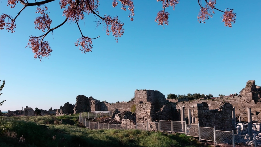 Panoramic view of ruins of Amphitheater in ancient city in Sideat sunrise, Alanya province, Turkey. Ruined old city. Unesco Cultural Heritage Monument. 