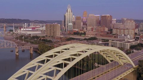 Aerial: Freeway traffic crossing the Daniel Carter Beard Bridge over the Ohio River. Cincinnati city skyline is in the distance, Ohio