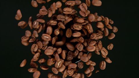 Super Slow Motion Shot of Rotating Coffee Beans in coffee grinder, Black Background. Filmed on high speed cinematic camera at 1000fps