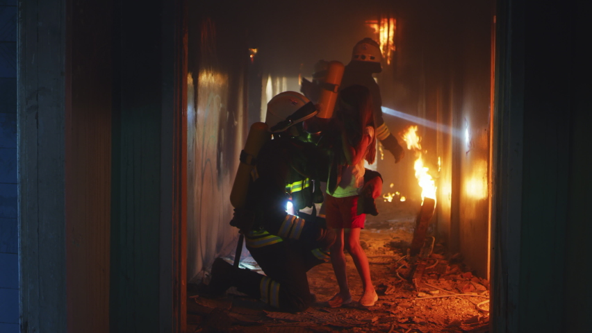 Fire fighters heroically carrying away helpless girl and searching for other survivors then leaving burning hallway during rescue operation Royalty-Free Stock Footage #1077742877