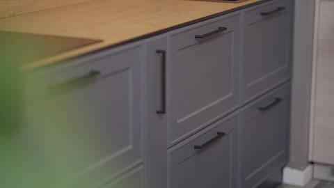 Male Caucasian hand opening and closing kitchen cabinet drawer with lights on and off inside. Unrecognizable male seller demonstrating modern furniture functionality in shop indoors