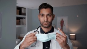 Mixed race male doctor standing in office wearing surgical mask