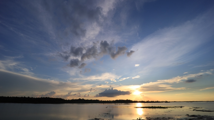 Time-lapse photography of evening sky, red, orange, yellow clouds over the river