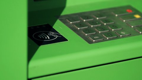 ATM keyboard. Street ATM with metal buttons for PIN code entry and control. Warm sunny day. Light green color. Bank terminal close up. Macro.
